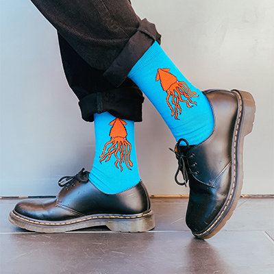 Bright blue socks with orange squid on them. 