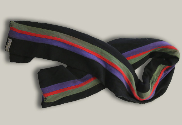 A scarf with black, green, purple and red stripes