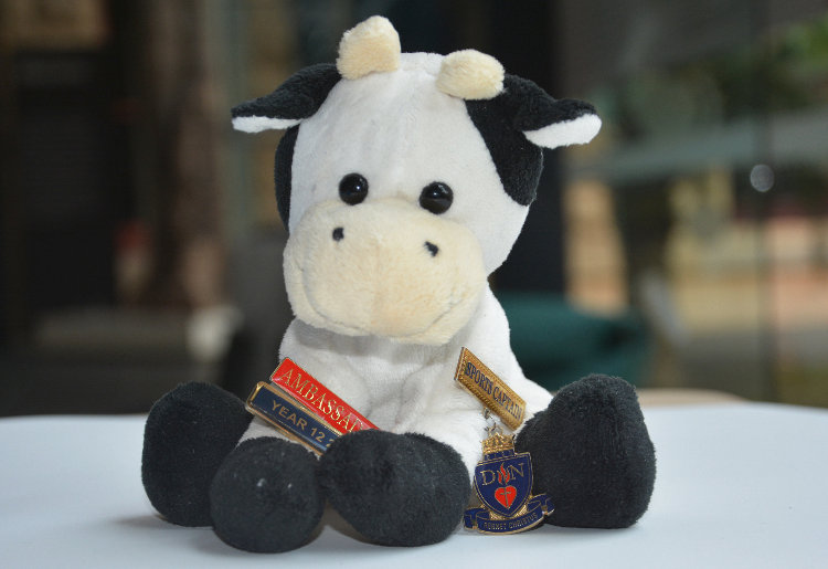 Plush cow toy with medals attached